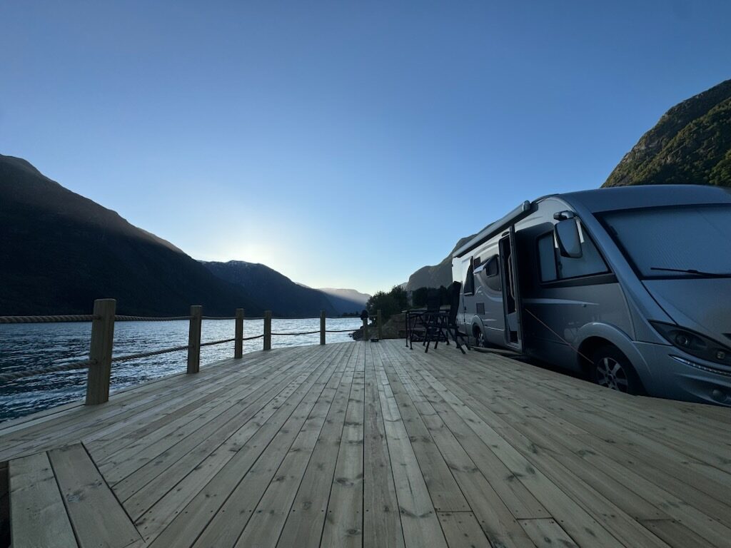 Bubil parkert inntil ein treterrasse ved Veitastrondsvatnet i kveldssol